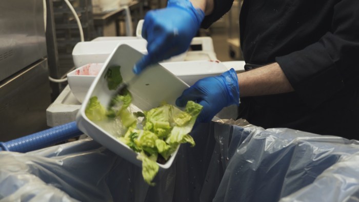 worker throwing food waste away